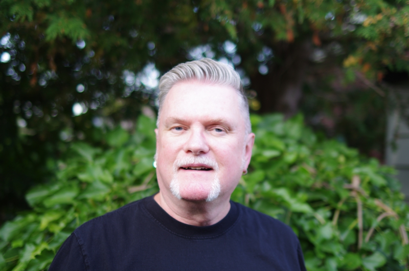 Portrait of David Moulton Counsellor for Toronto with an open expression standing in front of a mulberry bush