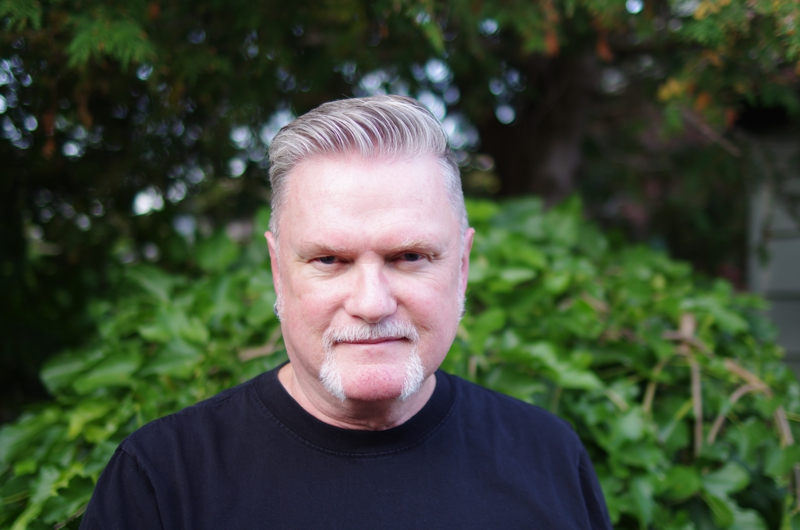 Portrait of David Moulton Counsellor for Toronto looking intently standing in front of a mulberry bush